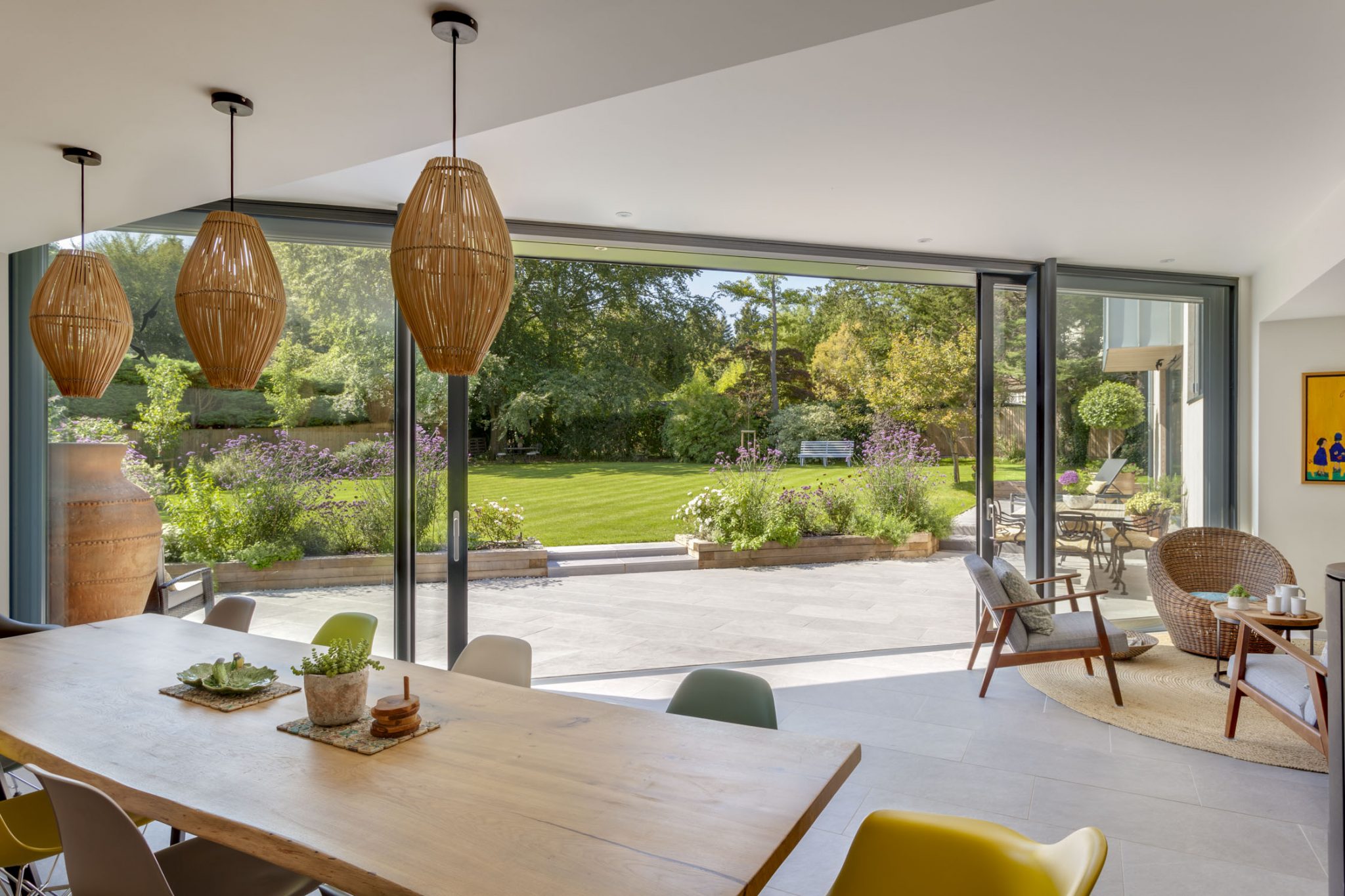 A modern room with bifold doors showing the interior and exterior valverdi matching indoor outdoor tiles.