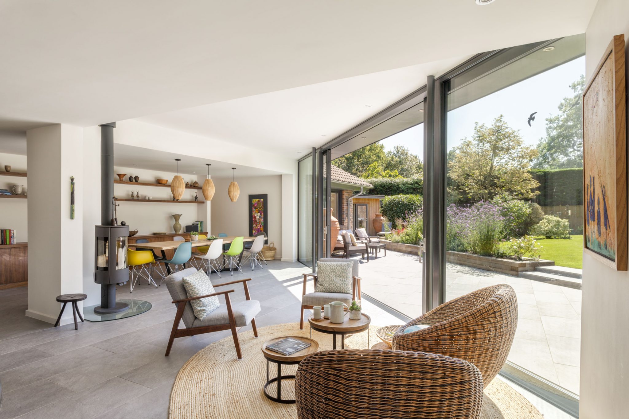 The interior of a modern spacious living room with valverdi indoor out tiles on the floor and outside.